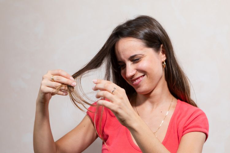 chica mirandose las puntas del pelo